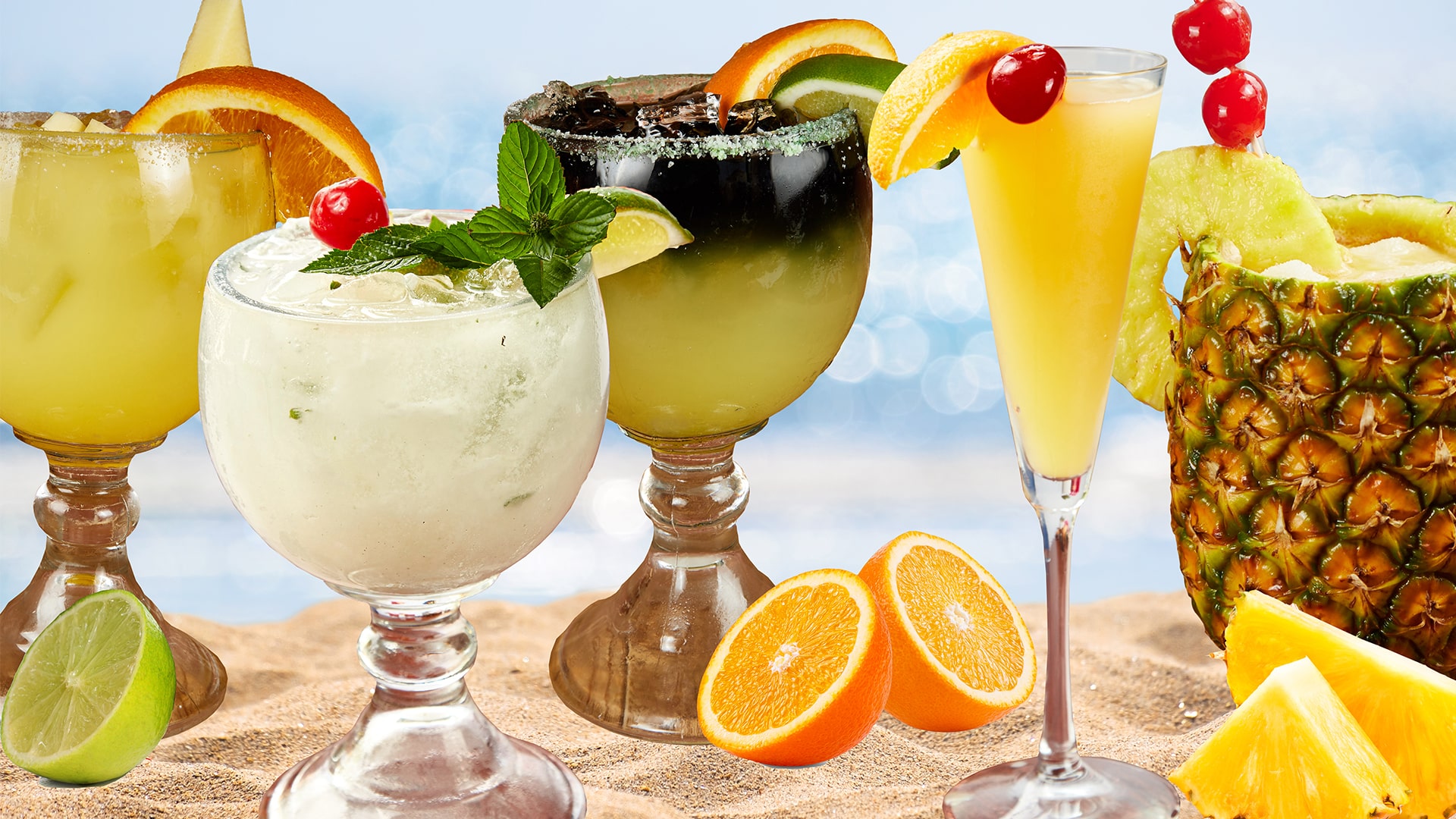 A row of frozen and fruit margaritas in wide bowl glasses with orange, lime, pineapple and cherry garnishes